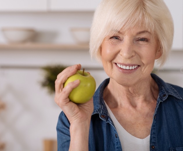 Woman smiling after all on four dental implant denture restoration