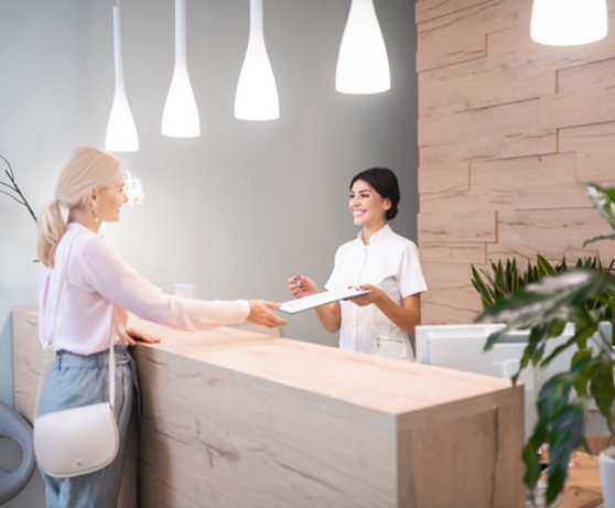 Patient with dental receptionist in Alexandria