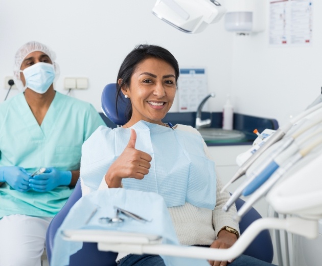 Oral surgery patient giving thumbs up after treatment
