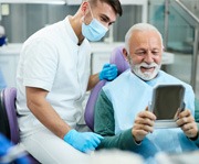 man smiling and looking in a small mirror