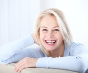 Older woman smiling wearing blue long sleeved shirt