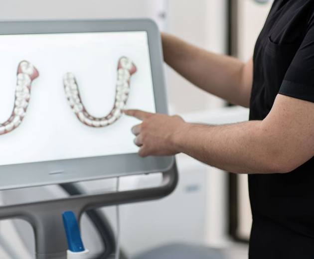 Dentist pointing at image on computer monitor