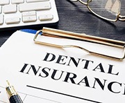 Dental insurance form resting on a table next to keyboard