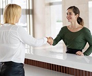 Patient shaking hands with a dental employee