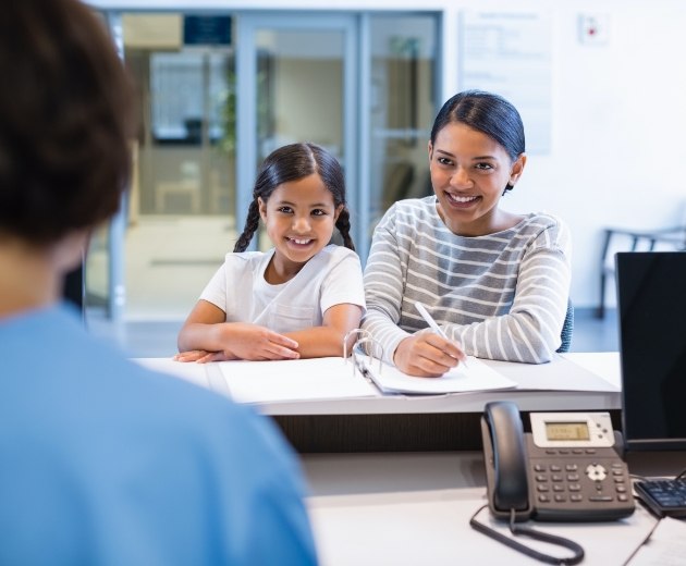 Mother and daughter filling out dental and medical insurance forms