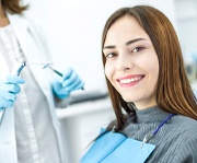 Woman smiling while visiting a sedation dentist in Alexandria