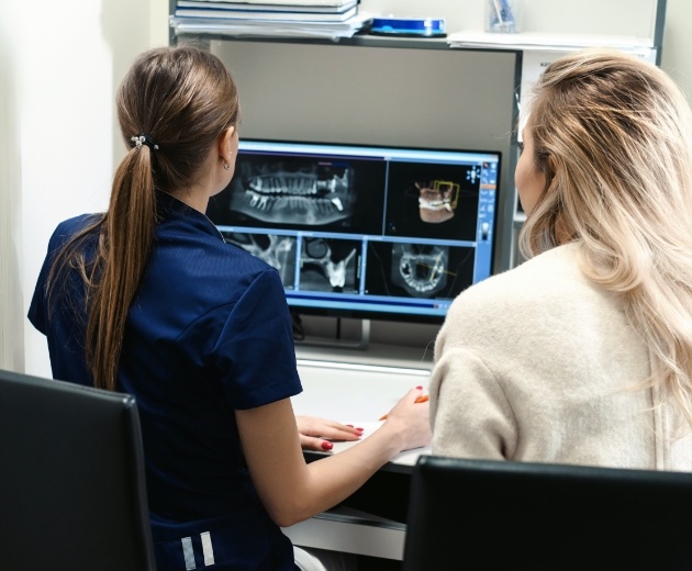 Team members reviewing C B C T cone beam imaging scans