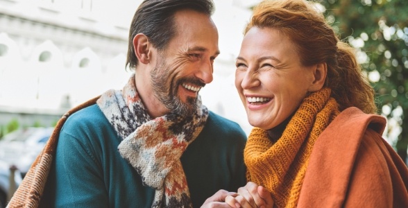 Man and woman smiling after general oral surgery procedures and technology treatment