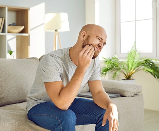 a man holding his mouth in pain