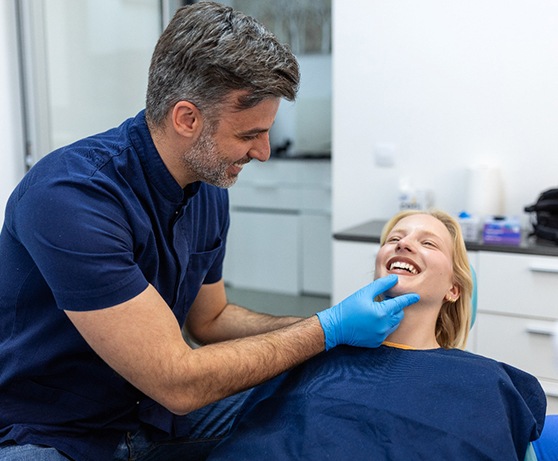 an oral surgeon examining a patient’s mouth