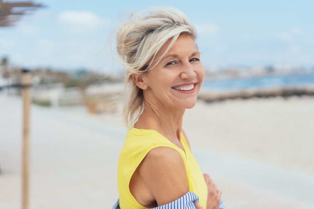 Woman with dental implants during the summertime.