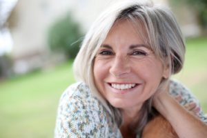 Older woman with dental implants enjoying the sunshine.