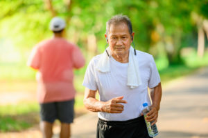 a person with headphones in running on a park trail