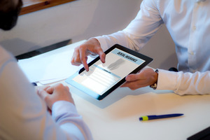 Showing patient a dental insurance form on a tablet