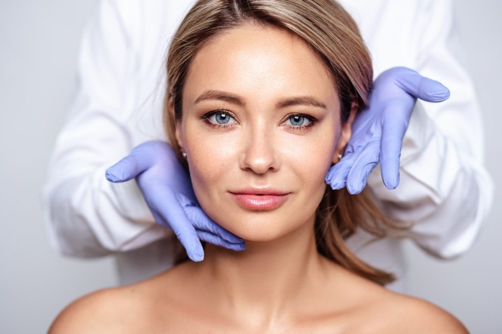 dentist wearing gloves touching face of BOTOX patient