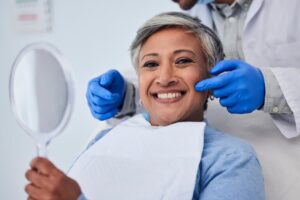 Woman smiling after getting dental implants